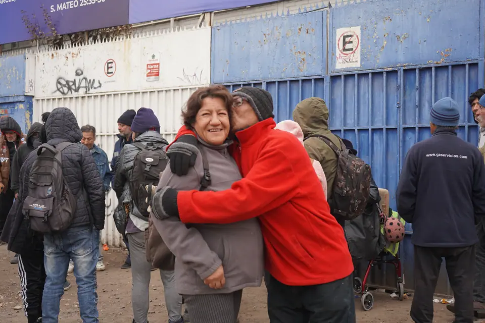 Voluntaria abrazando a un vecino afuera del Comedor Abierto